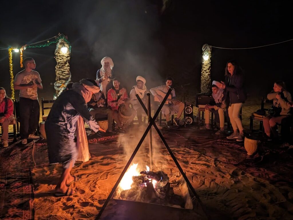 Dancing around the fire to local music at the camp.